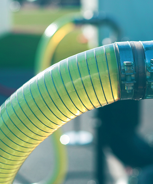 A close-up of a hose with a yellow nozzle, used for algae biodiesel production.