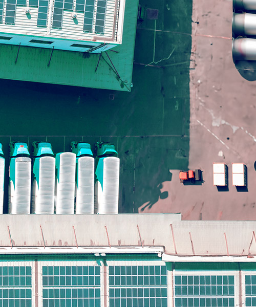 Aerial view of a building with heavy vehicle trucks lined in a row.